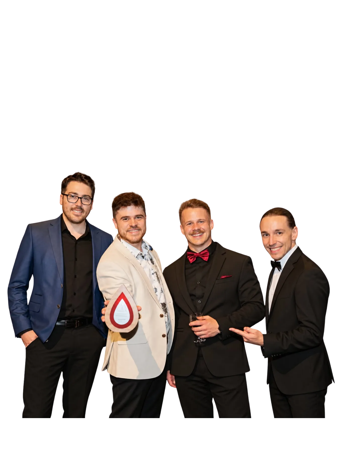 Quatre hommes souriants réunis, dont un tient un trophée.
